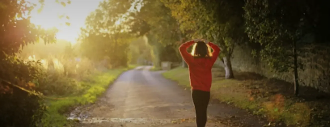 Woman walking on a sunlit country road